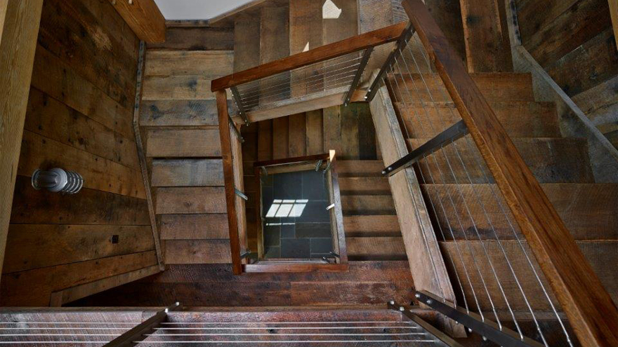 Farmhouse staircase design for home. Wood panelled staircase with cable rail.
