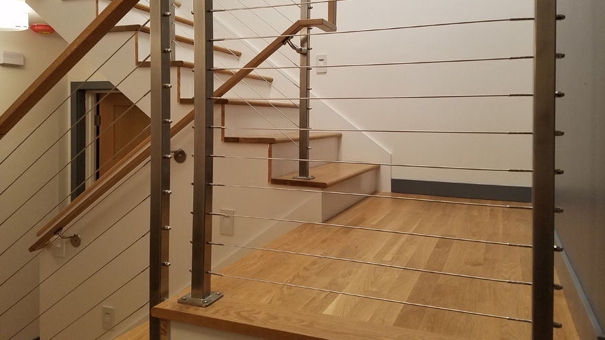 stair rail with a half wall design. Modern cable rail on stair makes a great railing for home.