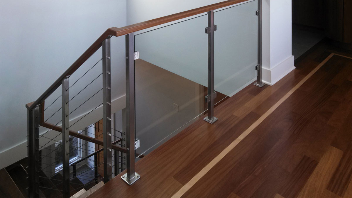 Glass panel railing infill on landing, matched with cable railing on stairs