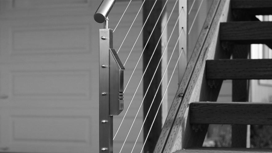 StarLight LED accent light on railing post. Cable rail on stairs with landscape lighting.