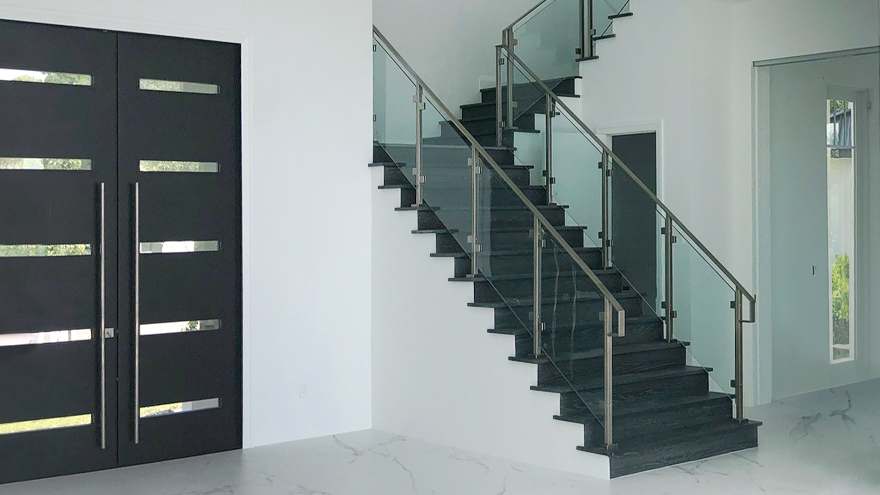 Glass stair railing in upscale property. The tempered glass panel infill is custom designed. The glass switchback staircase allows light to flow unemcumbered.