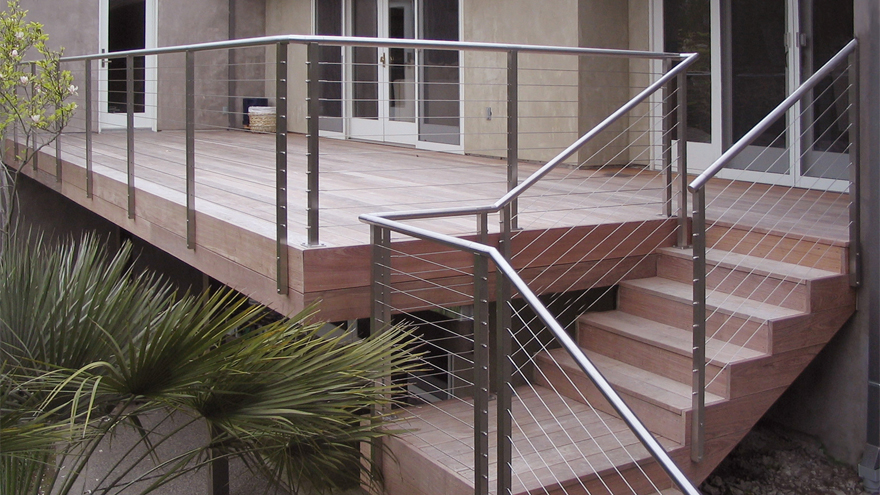 Wire railing on residential deck with dog leg stairs.