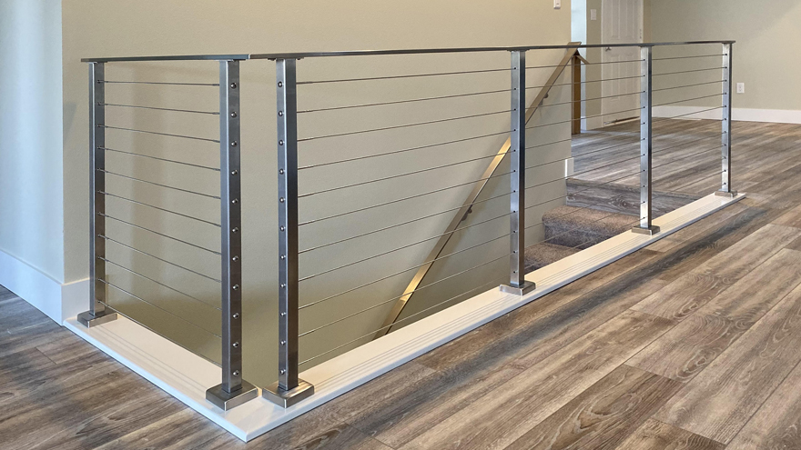 Cable railing on stairs and landing with matching handrail.