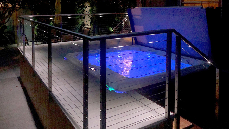 Wire railing system surrounding jacuzzi