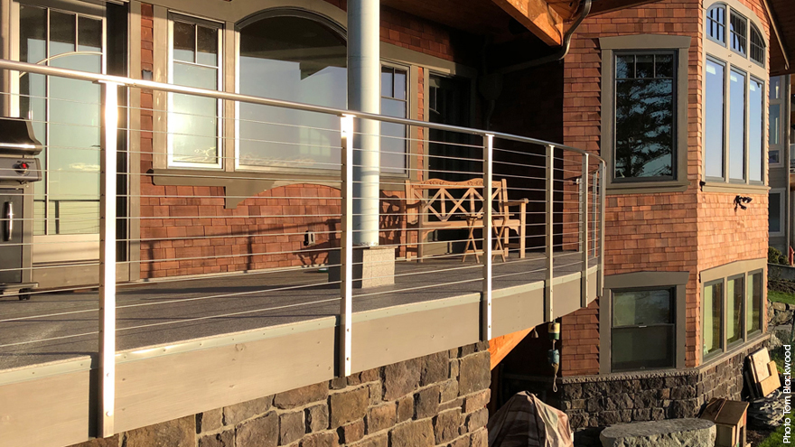 Home featuring two cable railing systems, one balcony railing and one lower deck railing. The balcony cable rail features modified railing posts.