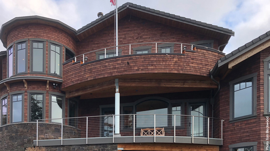 Home featuring two railing systems, one on the balcony and one on the deck.