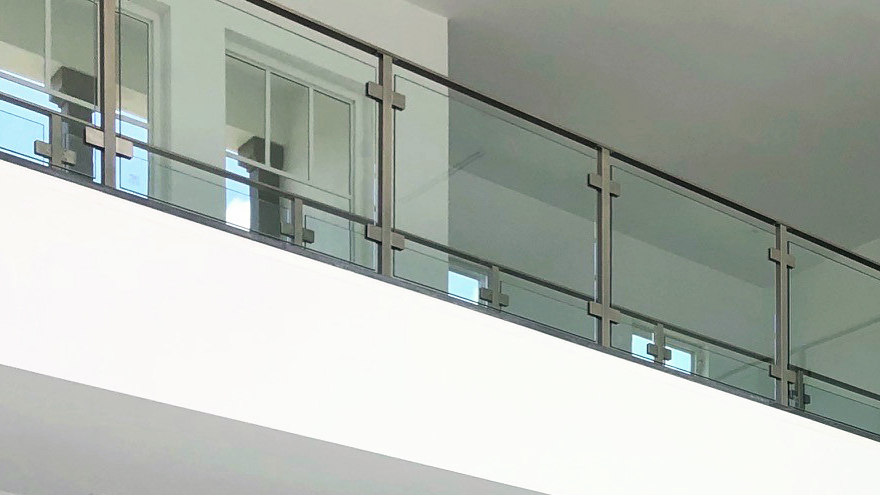 Modern glass balcony. The tempered glass is held in position with glass railing clamps.