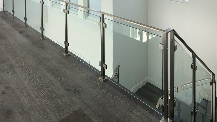 glass rail on stairs with flat metal handrail.