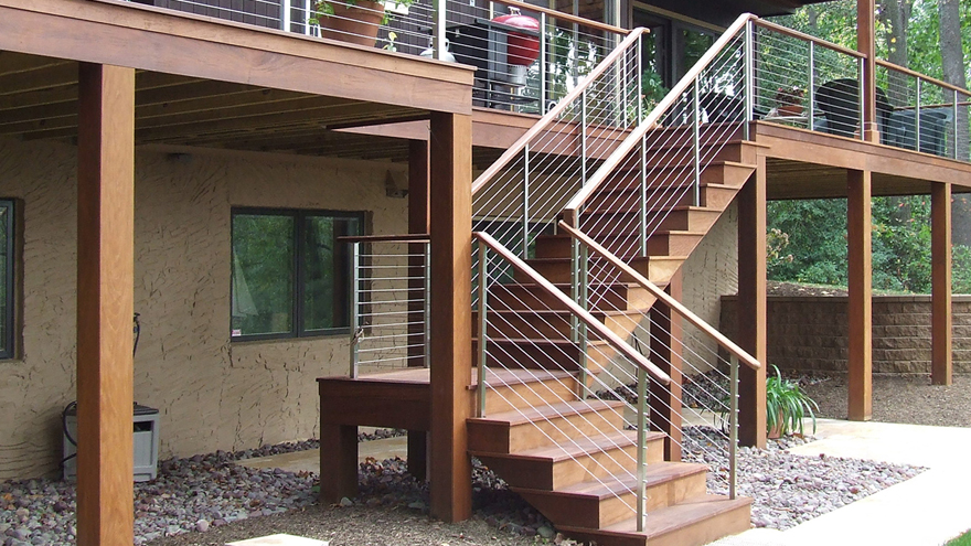 Dogleg deck staircase with modern railing design. Cable infill and stainless steel metal posts create a beautiful high end look.