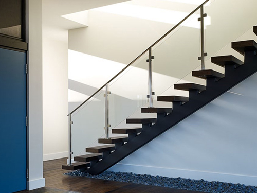 Glass rail on stairway. Railing for home includes glass panel infill.