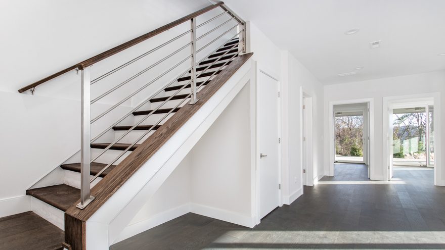 horizontal bar home railing system on stairs. Stainless steel modern railing designs are a popular railing design trend.