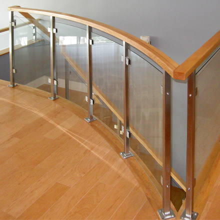 Curved glass stair railing in modern residential home.