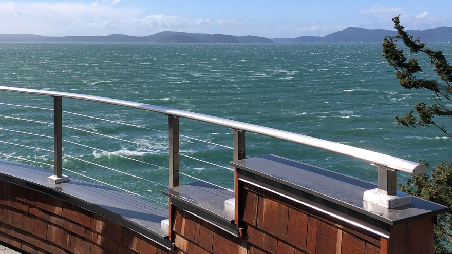 Pony wall cable rail. Custom height railing posts make installing this balcony half wall easy. The custom-built curved railing design looks stunning.