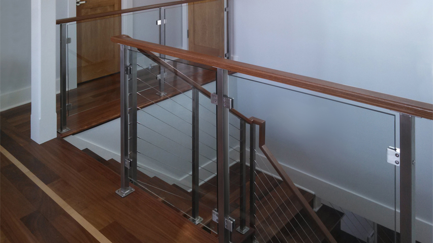Wood and glass railing combined creates a cohesive design. A glass railing indoor installation mixed with cable railing on steps creates a distinctive railing look.