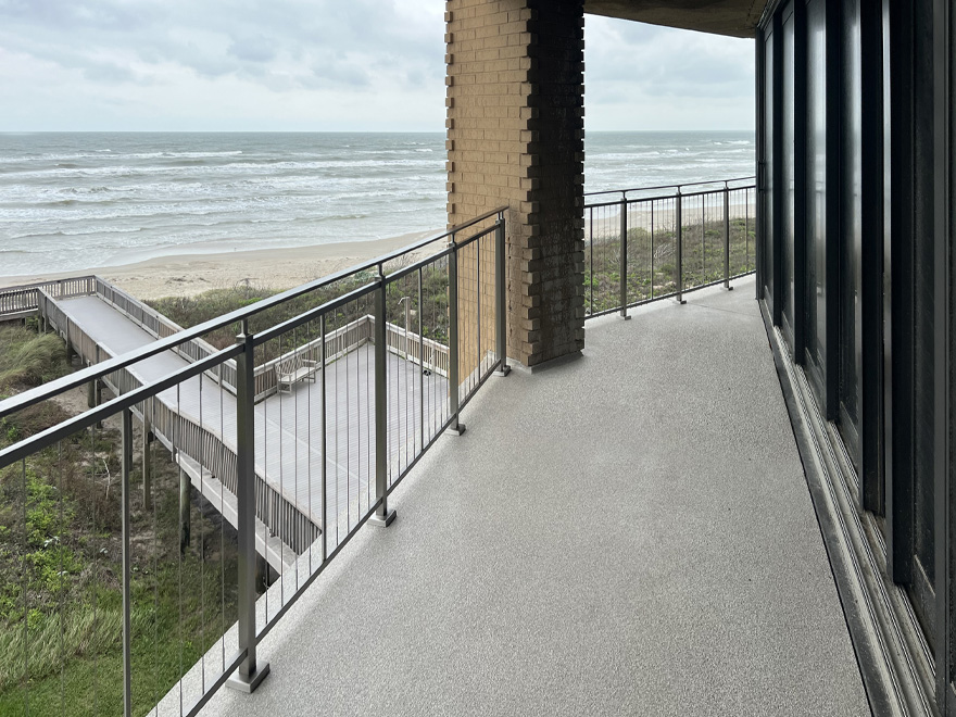 Balcony vertical cable rail with waterfront view. AGS manufactures vertical bar railing, vertical rod rail and vertical cable rail.